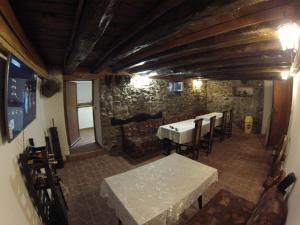 a room with a table and chairs and a stone wall at Къща за гости с минерална вода "Терма Асклепий" in Kyustendil