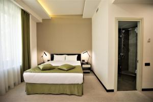 une chambre avec un lit et une douche à l'italienne dans l'établissement AnnaBella Boutique Hotel, à Erevan