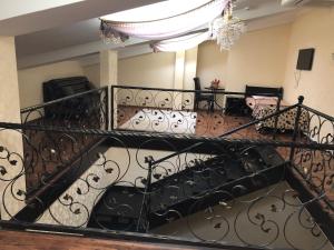 un escalier en colimaçon avec une balustrade en fer forgé dans l'établissement Hotel Meduza, à Kharkov