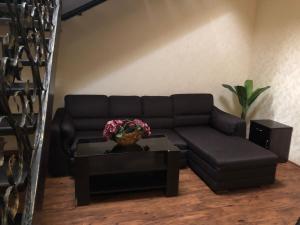 ein Wohnzimmer mit einem schwarzen Sofa und einem Tisch in der Unterkunft Hotel Meduza in Kharkov