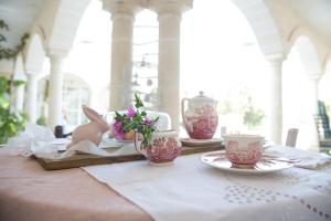 a table with plates and cups and flowers on it at filobrocante in Torre Santa Susanna