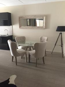 ein Esszimmer mit einem Tisch, Stühlen und einem Spiegel in der Unterkunft Kindred Lodge Apartments in Leeton