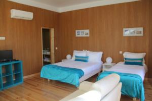 een woonkamer met 2 bedden en een bank bij Loulé Estúdios in Porto
