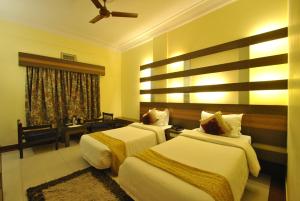 a hotel room with two beds and a window at Hotel Siddharth in Varanasi