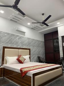 a bedroom with a bed with a ceiling fan at Hotel Amar Leela in Dehradun
