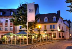 a hotel with tables and chairs in front of a building at Zur Alten Schmiede in Naumburg