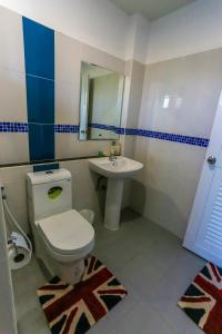 a bathroom with a toilet and a sink at Tempo Plus Apartment in Mae Sot