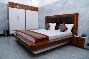 a bedroom with a large bed with white cabinets at Hotel Amar Leela in Dehradun