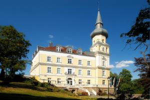 duży biały budynek z wieżą na górze w obiekcie Hotel Schloss Schwarzenfeld w mieście Schwarzenfeld