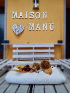 a table with a sign that says mason manu at Maison Manu in Perosa Argentina