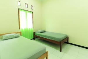 a room with two twin beds and a window at Villa Kangen Omah in Mojokerto +35 photos