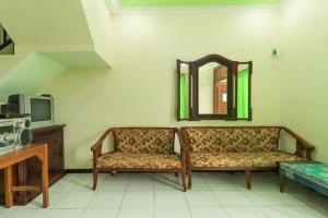 salon z kanapą i lustrem w obiekcie Villa Kangen Omah w mieście Mojokerto