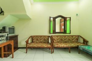 a living room with a couch and a mirror at Villa Kangen Omah in Mojokerto