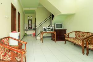 a living room with two chairs and a tv at Villa Kangen Omah in Mojokerto