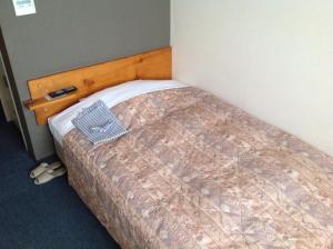 a bedroom with a bed with a wooden head board at Asano Hotel in Kitakyushu
