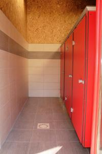 a room with red lockers and a tile floor at La Ferme du Marais Poitevin - Roulotte in Benet