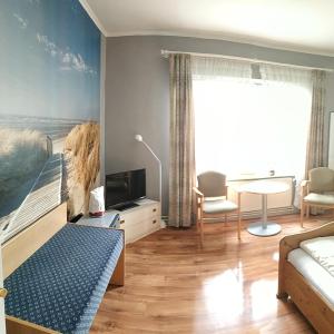 1 dormitorio con 1 cama y 1 mesa con sofá en Atlantis Landpension Steinhude, en Wunstorf