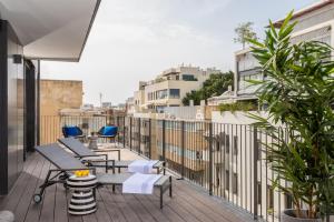 a balcony with chairs and tables on a building at master Shenkin in Tel Aviv