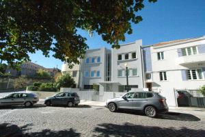 three cars parked in a parking lot in front of a building at OPO.APT - Art Deco Apartments in Oporto's Center in Porto