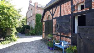 een bakstenen gebouw met een bank naast een deur bij Ferienhaus-fuer-die-Grossfamilie-oder-Gruppenhaus-auf-dem-Ferien-und-Bauernhof-Nielson-in-Inselmitte in Bisdorf