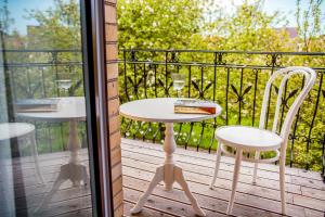 stół i krzesła na balkonie ze szklanymi drzwiami w obiekcie Willa Laguna w Kołobrzegu
