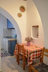 a kitchen with a table with a red and white table cloth at Volta Stonehouse Apartments in Frátsia
