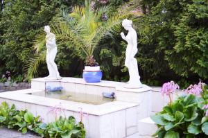 dos estatuas de mujeres en una fuente en un jardín en Park Hotel Turku en Turku