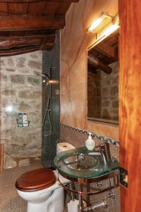 a bathroom with a toilet and a sink at Alojamiento rural "El Torreón" in Sabiote