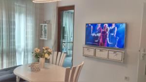 sala de estar con mesa y TV en la pared en Luxury Sunrise Complex Apartment, en Golden Sands