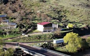 a house on the side of a hill next to a road at Taoskari Hotel in Vardzia