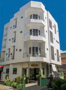 a white building with balconies on a street at Cool Stay Inn in Boracay
