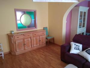 a living room with a dresser with a mirror and a couch at Espacioso piso en el corazón de Oliva in Oliva