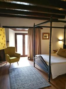 a bedroom with a four poster bed and a chair at Palacio de Monjaraz in Ávila
