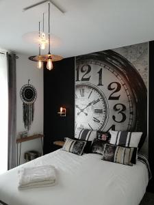 a bedroom with a large clock on the wall at Entre Honfleur et Etretat in Octeville-sur-Mer