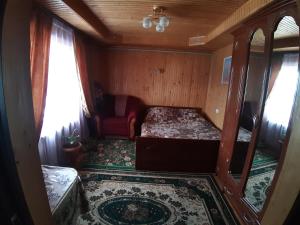 um quarto com uma cama e uma cadeira num comboio em Затишні Карпати)) em Verkhovyna
