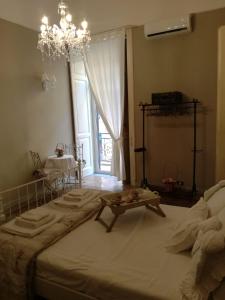 Cette chambre comprend un grand lit et un lustre. dans l'établissement Live and Love, à Naples