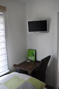 a bedroom with a desk with a television and a chair at Ferienapartment am See in Wettringen