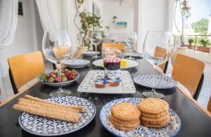 a table with plates of food and glasses of wine at Casa Bianca - Good Living in Preveza