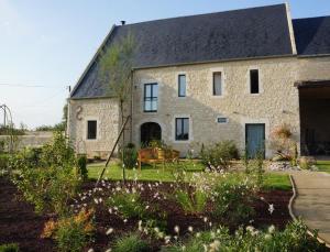 ein altes Steinhaus mit Garten davor in der Unterkunft B&B Les Oiseaux de Passage in Isigny-sur-Mer