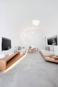 uma sala de estar com mobiliário branco e uma televisão de ecrã plano em Anemolia Villa em Megalokhori