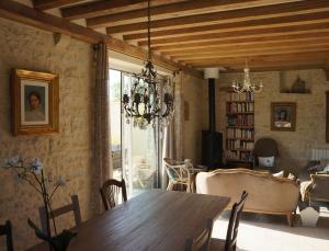 sala de estar con mesa de madera y comedor en B&B Les Oiseaux de Passage, en Isigny-sur-Mer
