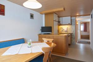 une salle à manger avec une table et une cuisine dans l'établissement Haus Wasserfall, à Sankt Gallenkirch