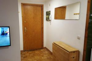 a hallway with a wooden door and a wooden box at Apto VIELHA CENTRO Internet fibra in Vielha