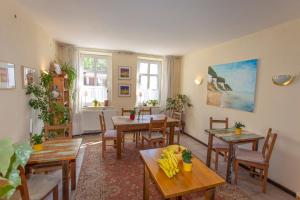 a dining room with tables and chairs and windows at Alte Schmiede Putbus in Putbus