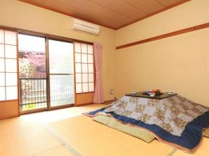 um quarto com uma cama e uma janela grande em 布引観音温泉 em Ōhinata