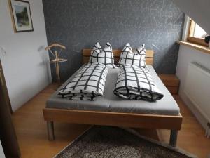 a bed with black and white pillows on it at Ferienwohnung Diepold in Wasserburg