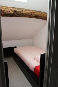 ein kleines Bett in einem kleinen Zimmer mit in der Unterkunft Gite des Celliers in Alise-Sainte-Reine