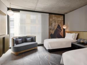 a hotel room with a bed and a chair at Nobu Hotel London Shoreditch in London