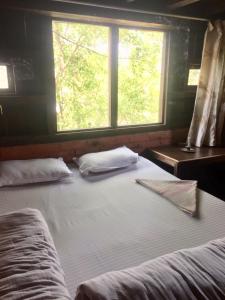 a large bed with two pillows in a room with a window at Hotel At The End Of The Universe in Nagarkot