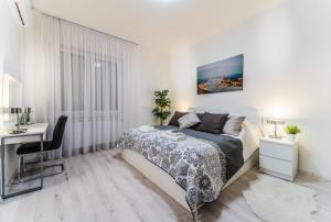 ブダペストにあるABC Apartmentの白いベッドルーム(ベッド1台、デスク付)
